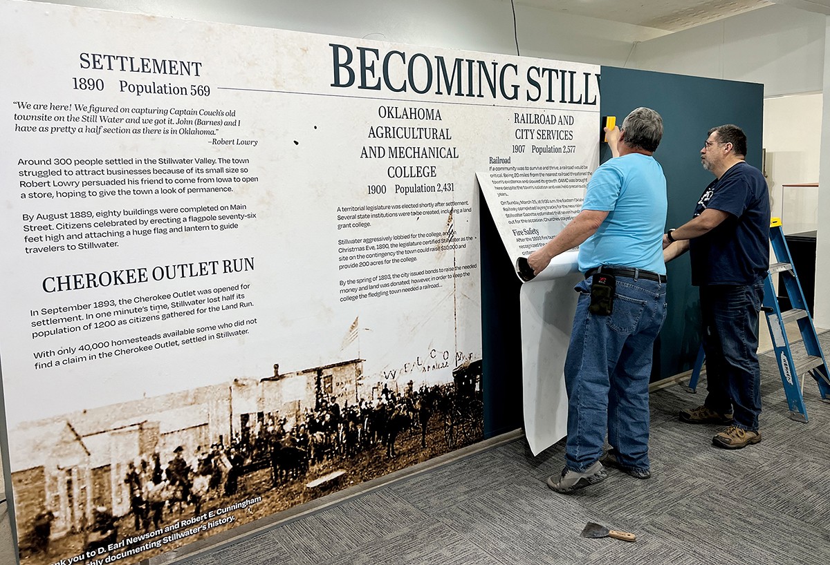 Oklahoma CareerTech Printing, Distribution and Client Services Division employees install a wall wrap at the Stillwater History Museum.