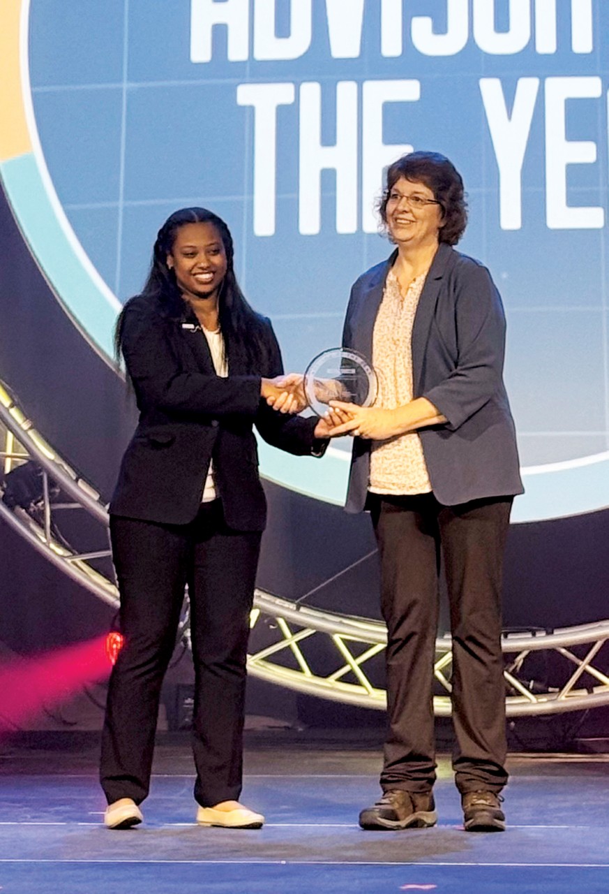 Amy McClure, right, Northwest Technology Center - Fairview, receives the Advisor of the Year award at the Business Professionals of America 2025 National Leadership Conference.