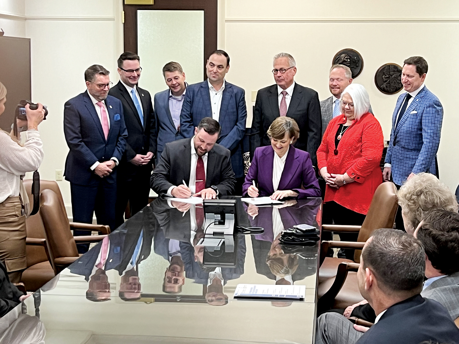 Oklahoma CareerTech State Director Brent Haken, seated left, and Oklahoma State Regents Chancellor Allison Garrett, seated right, sign a memorandum of understanding to establish guidelines for public two-year colleges to award students credit for prior learning in practical nursing programs at technology centers across the state.