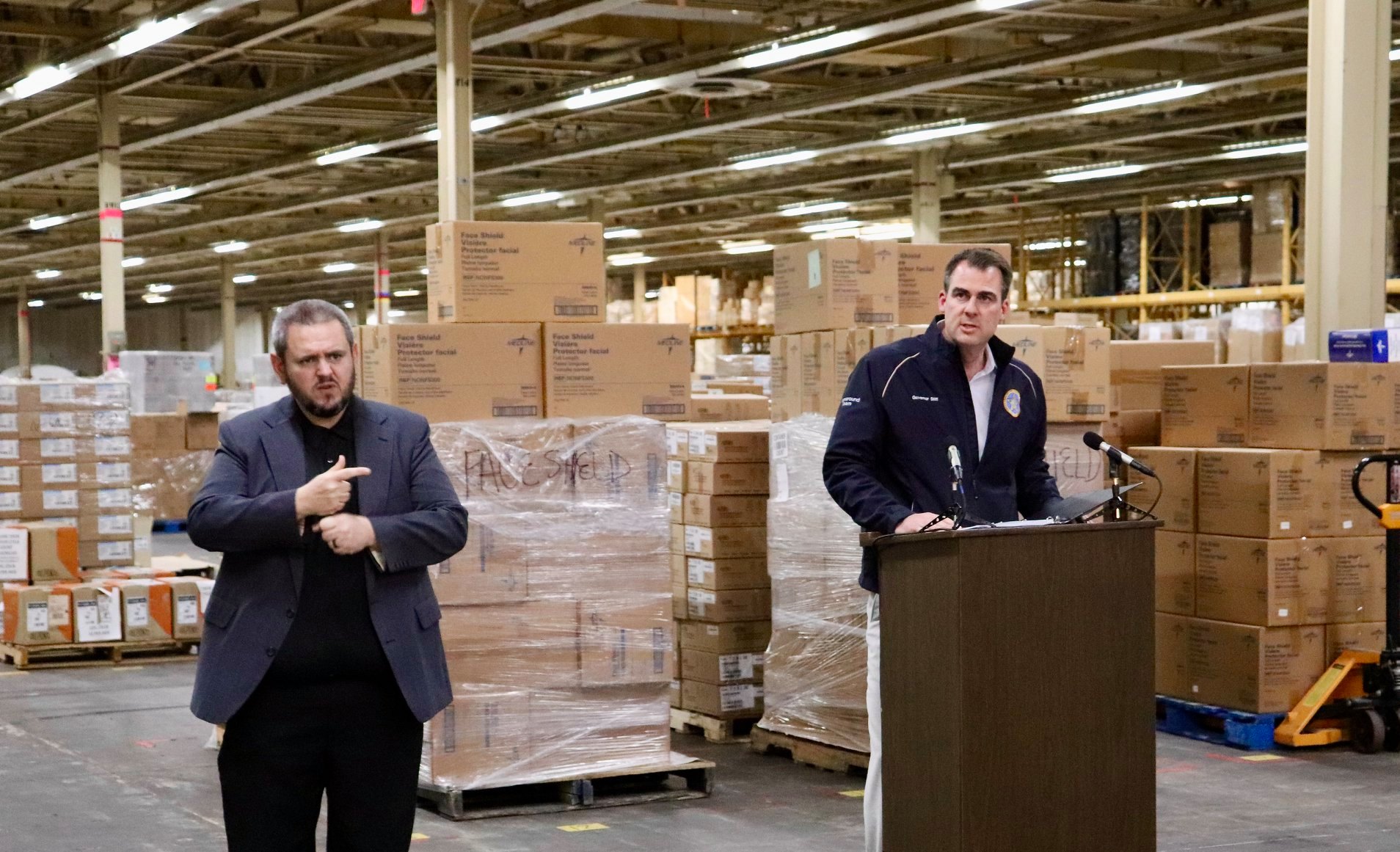 Governor Stitt press conference with PPE supplies in background