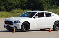 white car avoiding cones on a training track