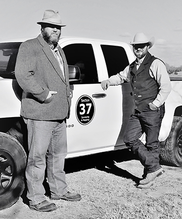 Marcus Heilman and Tyler Matthesen of Section 37 Surveying and Mapping stand next to a company truck.