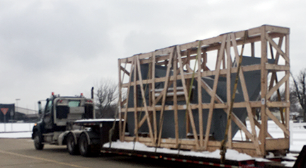 A truck carries a KC-135 outboard wing on a flatbed trailer.