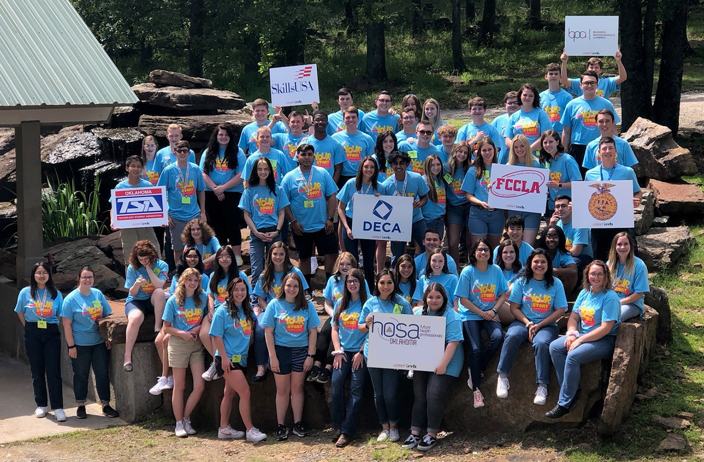 CareerTech student organization officers hold up their CTSO signs at Camp Tulakogee during CareerTech University.