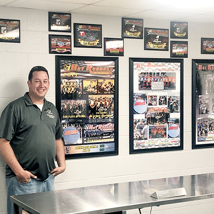 Nathan Dial stands next to Pontotoc Tech Center's Hot rodders of Tomorrow awards.