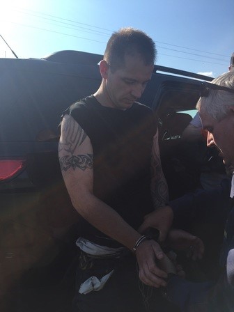 Law enforcement takes Johnny Simmons into custody Wednesday afternoon near Coleman.