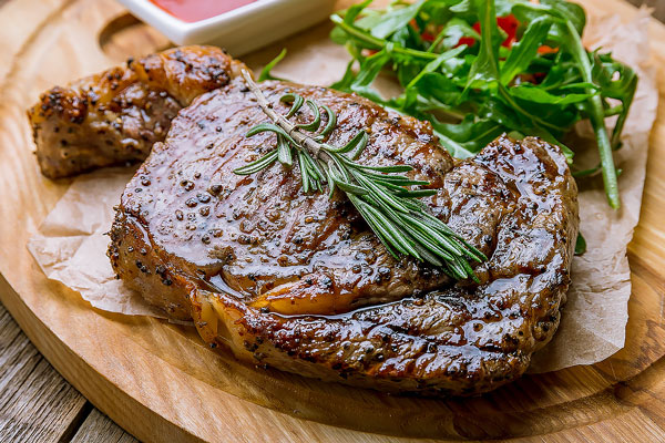 juicy Ribeye steak on wooden background