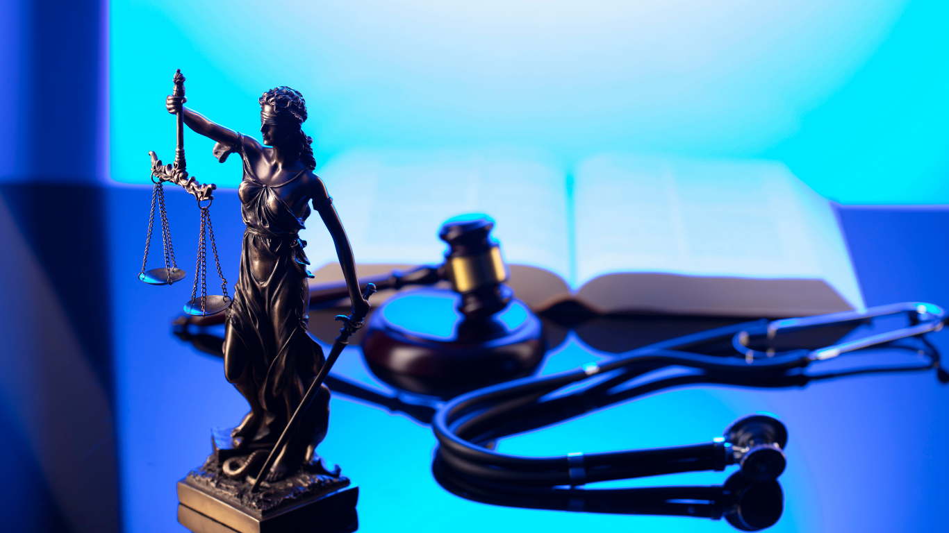 Medical law book, justice of the peace statue, with gavel and stethoscope 