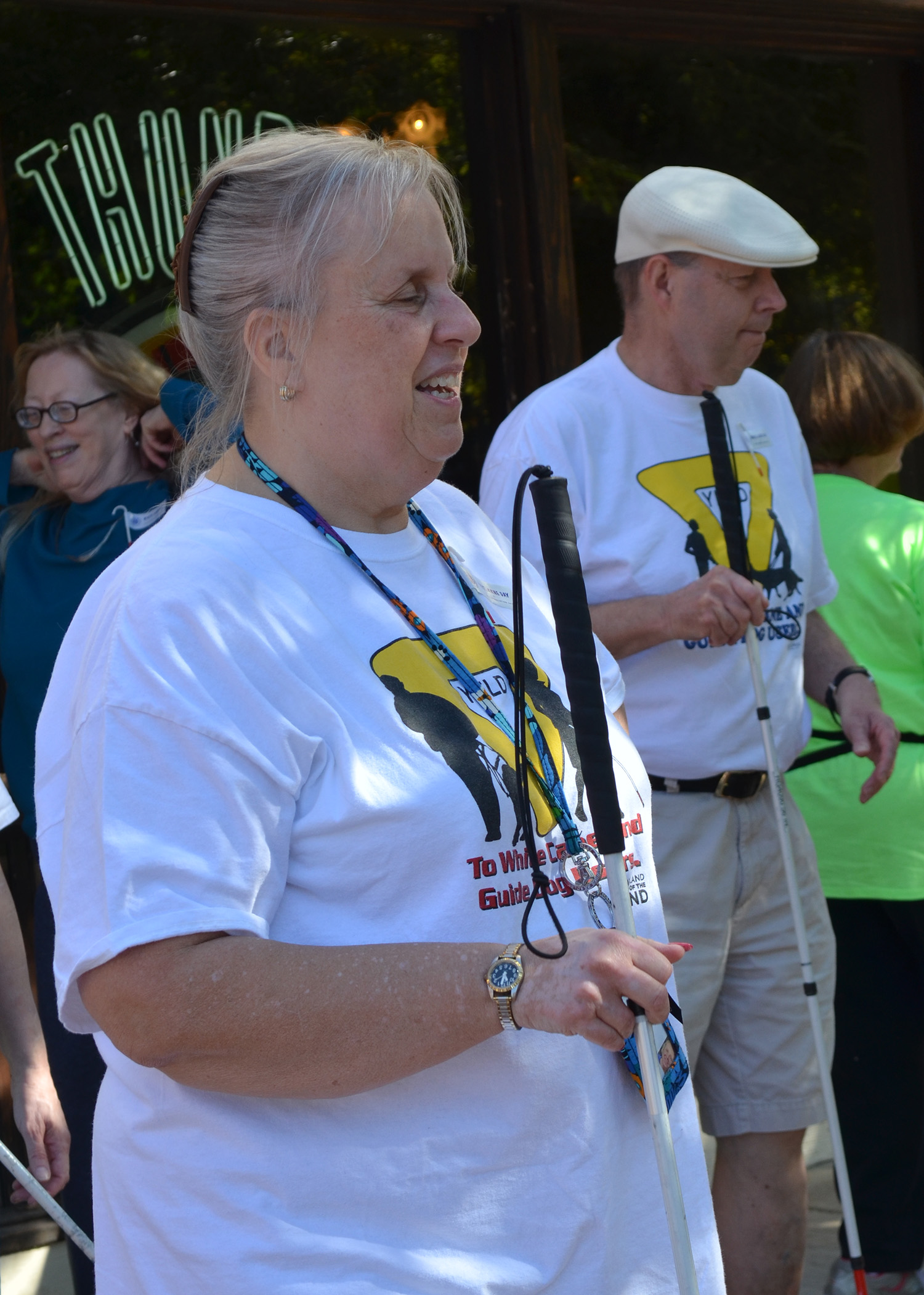 Woman holds white cane and stands in front of man holding white cane