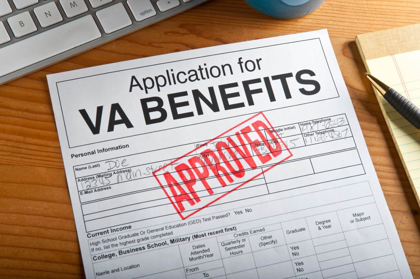 VA Benefits Approved stamped application on desk