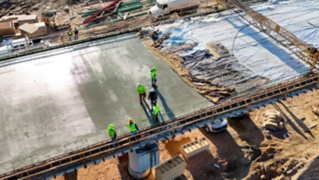 Workers walk and inspect cured concrete of the new SH-94 bridge.