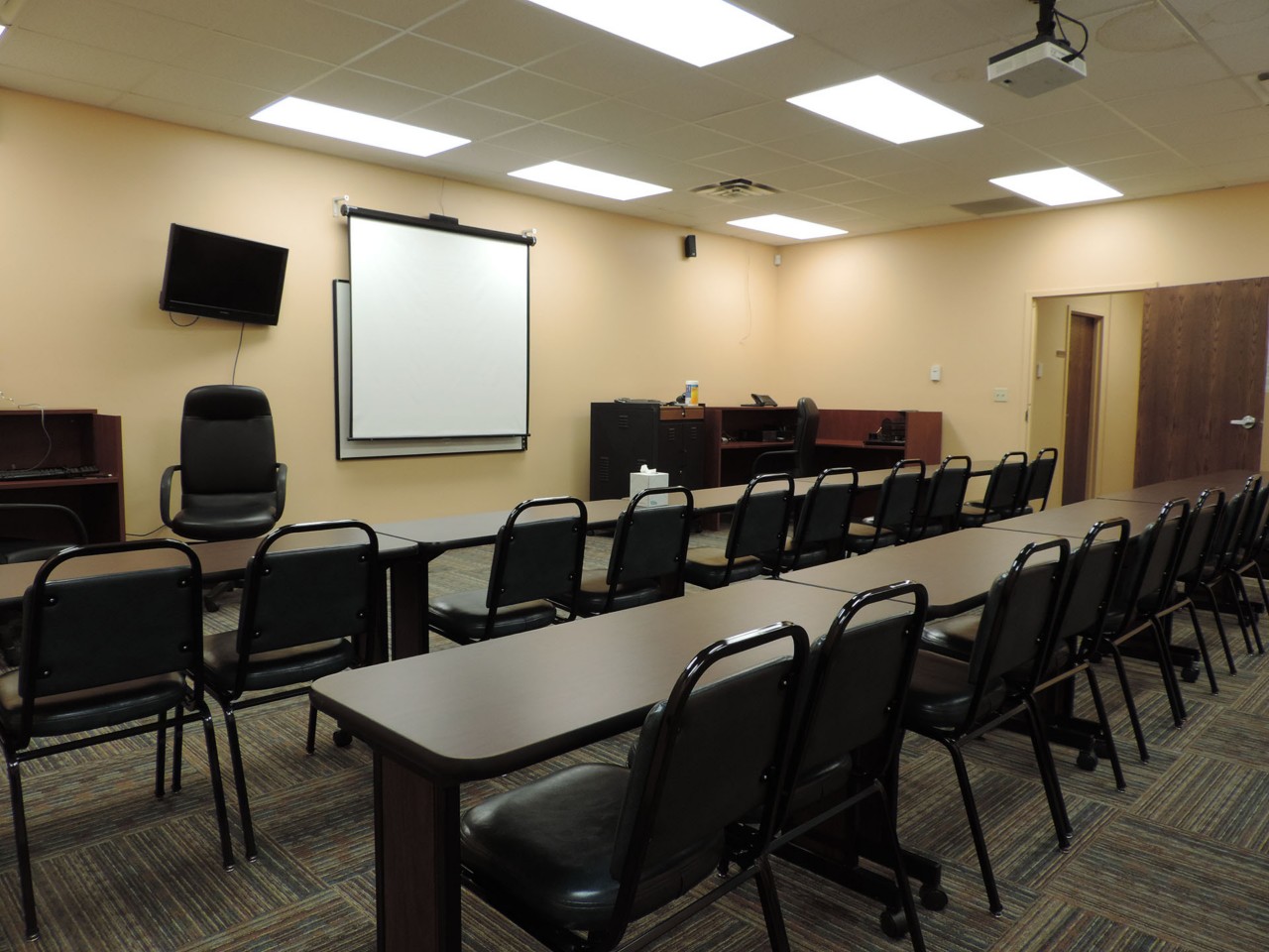 Conference or training room with available projector, white board, and tables/chairs.