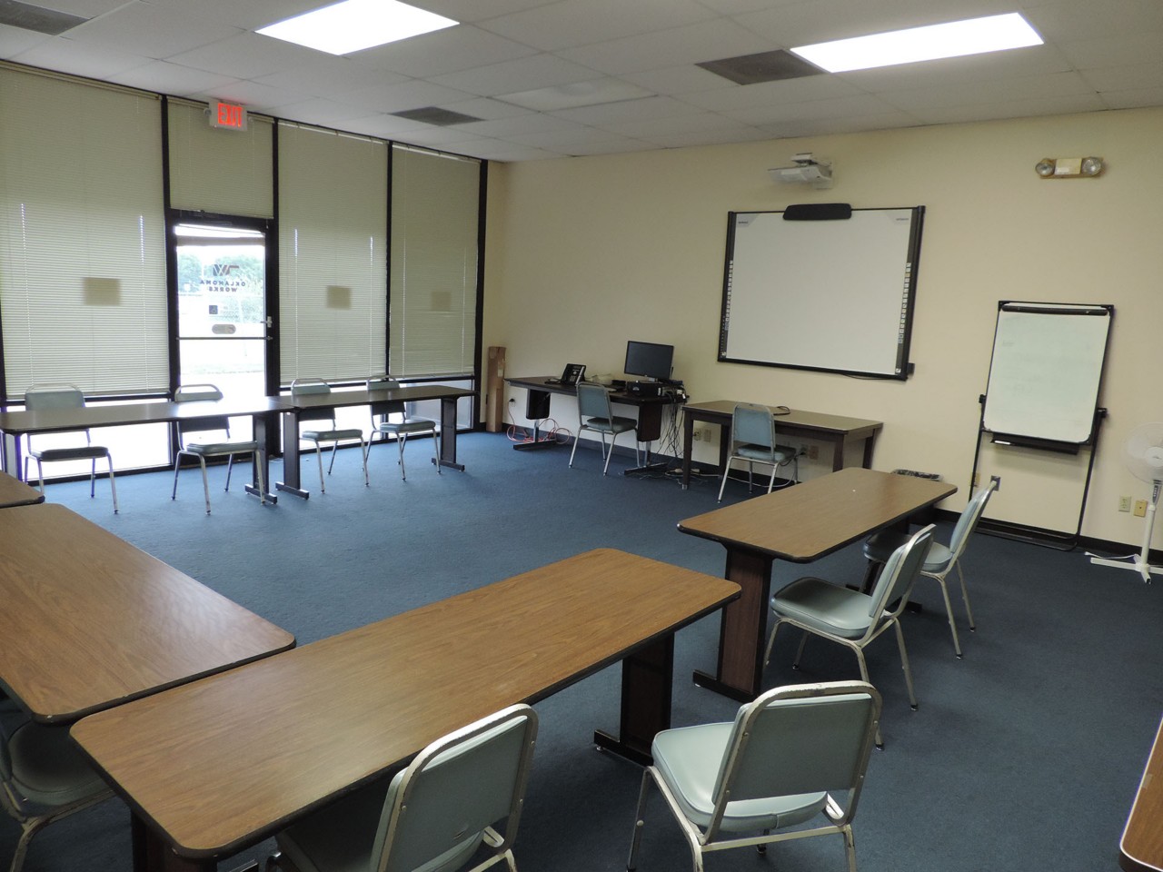 Conference or training room with available smart board, white board, and tables/chairs.