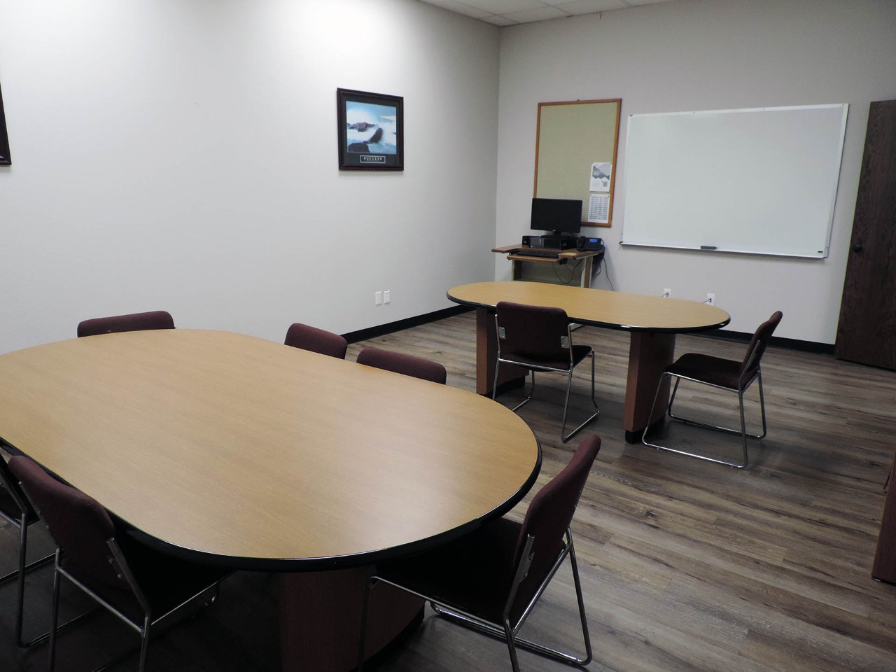 Conference or training room with available computer, white board, and table/chairs.          