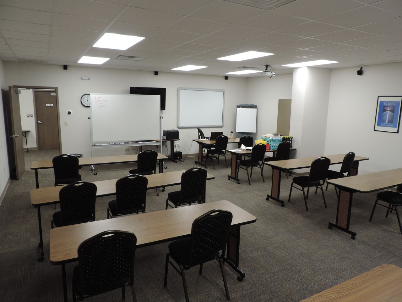 Conference or training room with available projector, TV, white board, and tables/chairs.