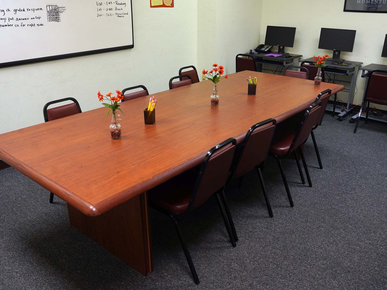Conference or training room with available computers, white board, and table/chairs.                               