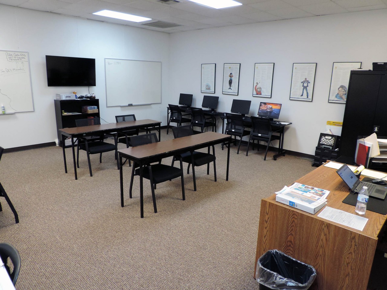Training or testing room with available desks, cabinets, computers, TV and white boards.          