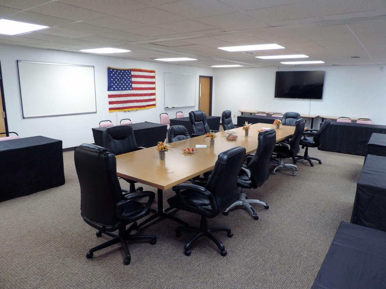 Conference room with available TV, white boards, and table/chairs.          