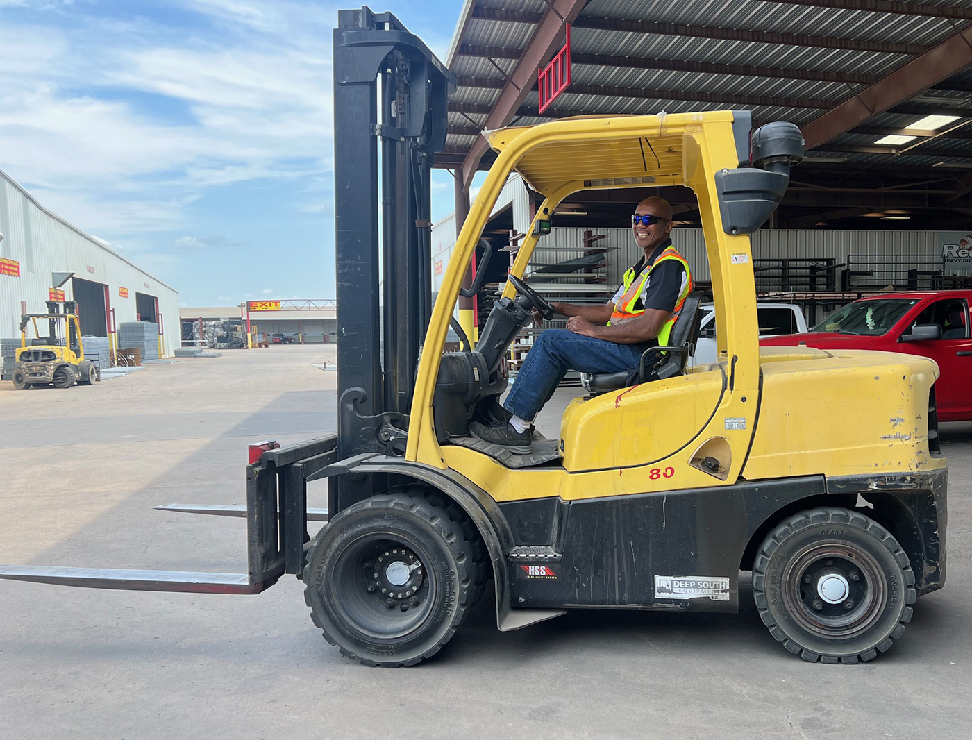 Man driving forklift smiling at camera