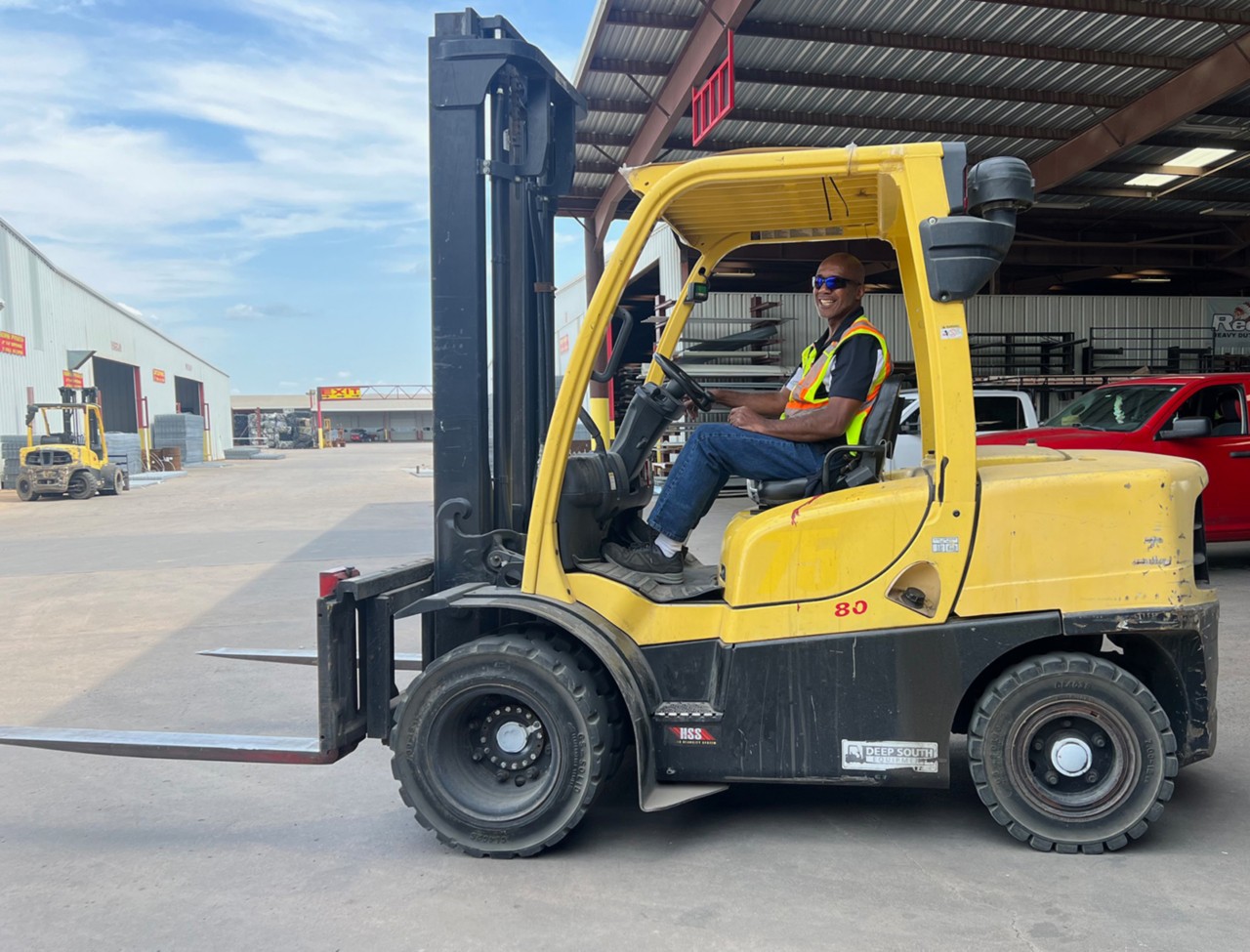 Man driving forklift smiling at camera