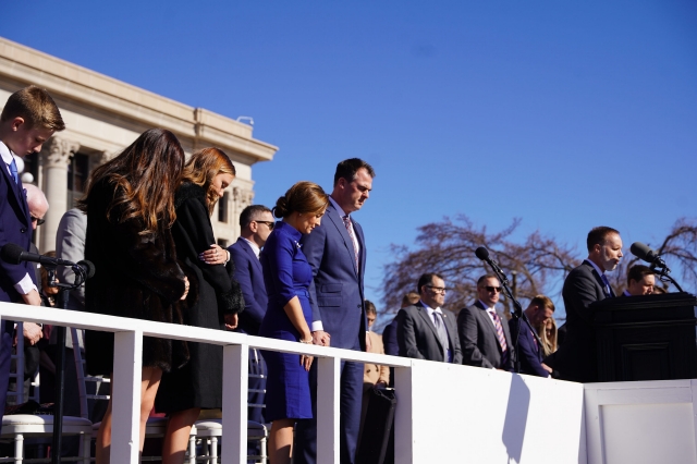 Governor Kevin J. Stitt praying with a group of people on ingurgitation day