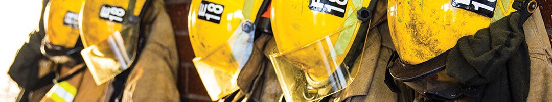 five yellow fire helmets hanging on a wall