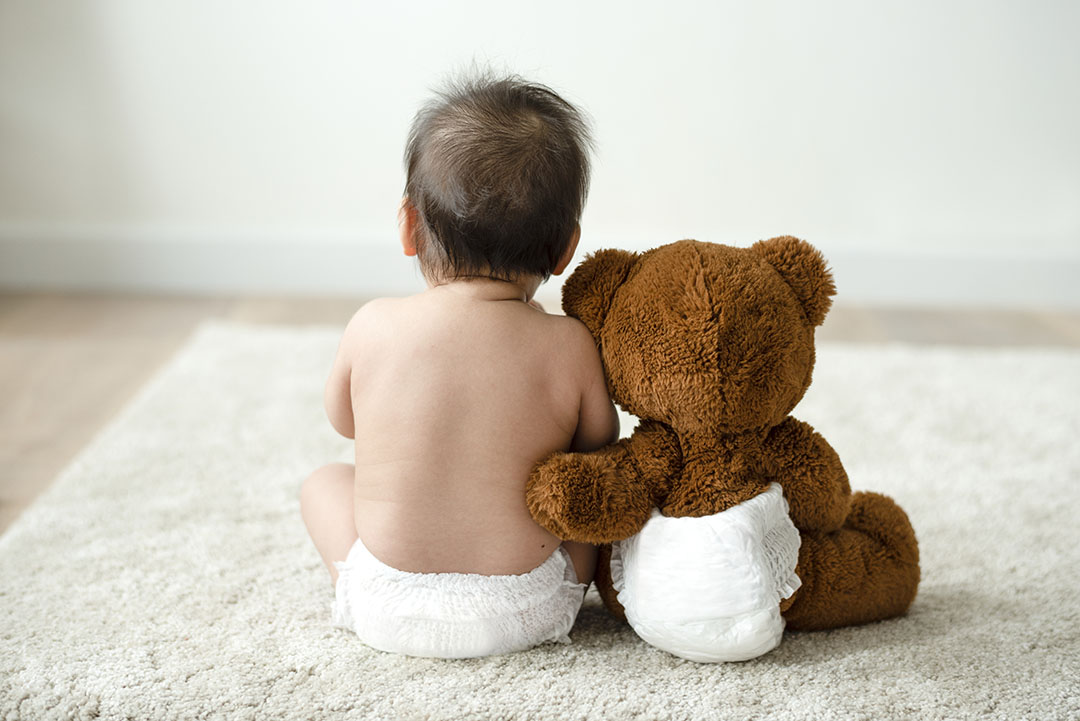 Back of a baby with a teddy bear Back of a baby with a teddy bear
