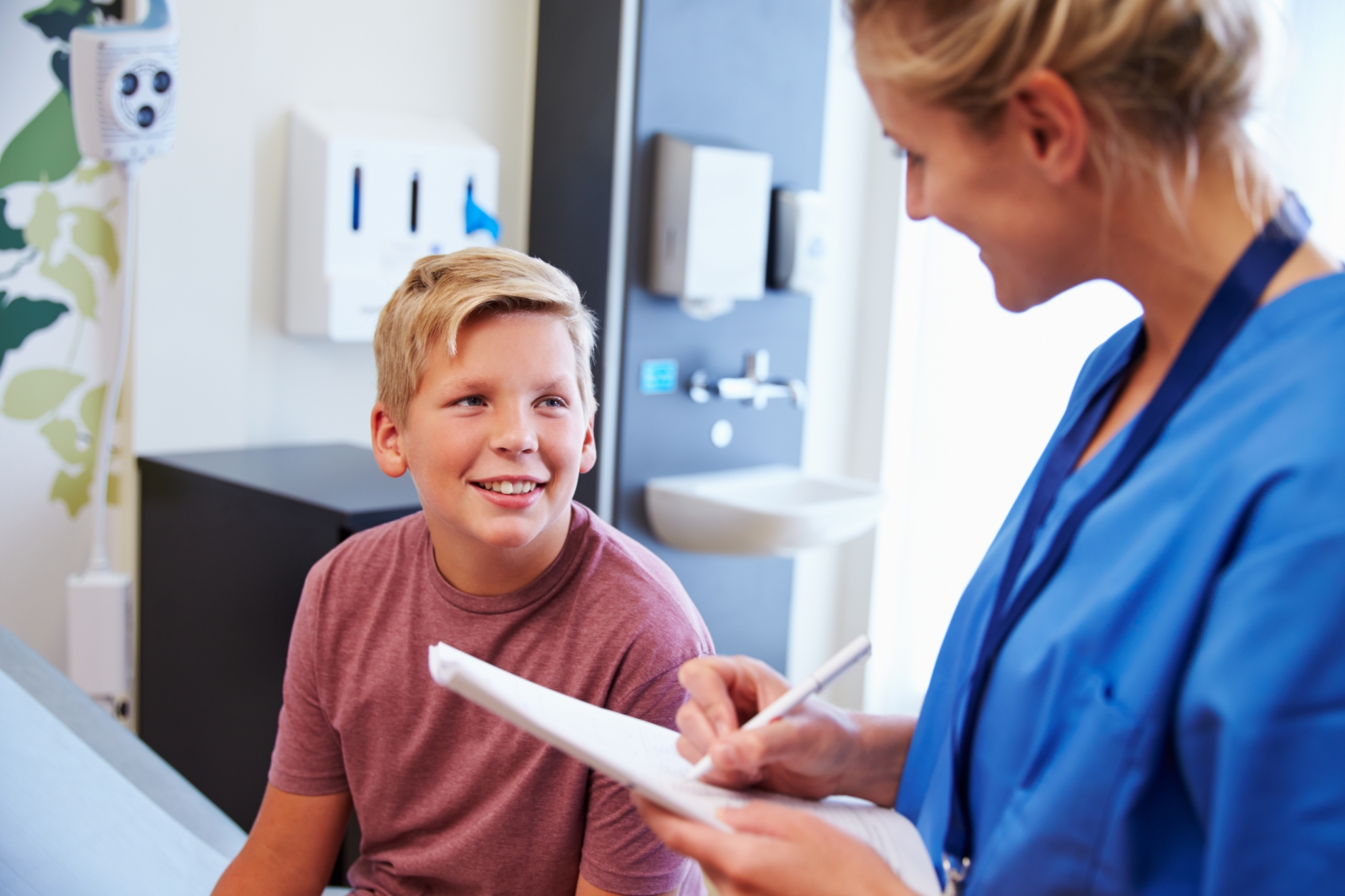 Teenage Boy And Doctor Have Consultation In Hospital Room Teenage Boy And Doctor Have Consultation In Hospital Room