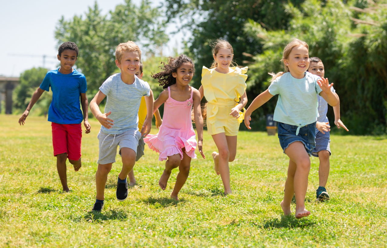 Cheerful kids are jogging together in the park and having fun