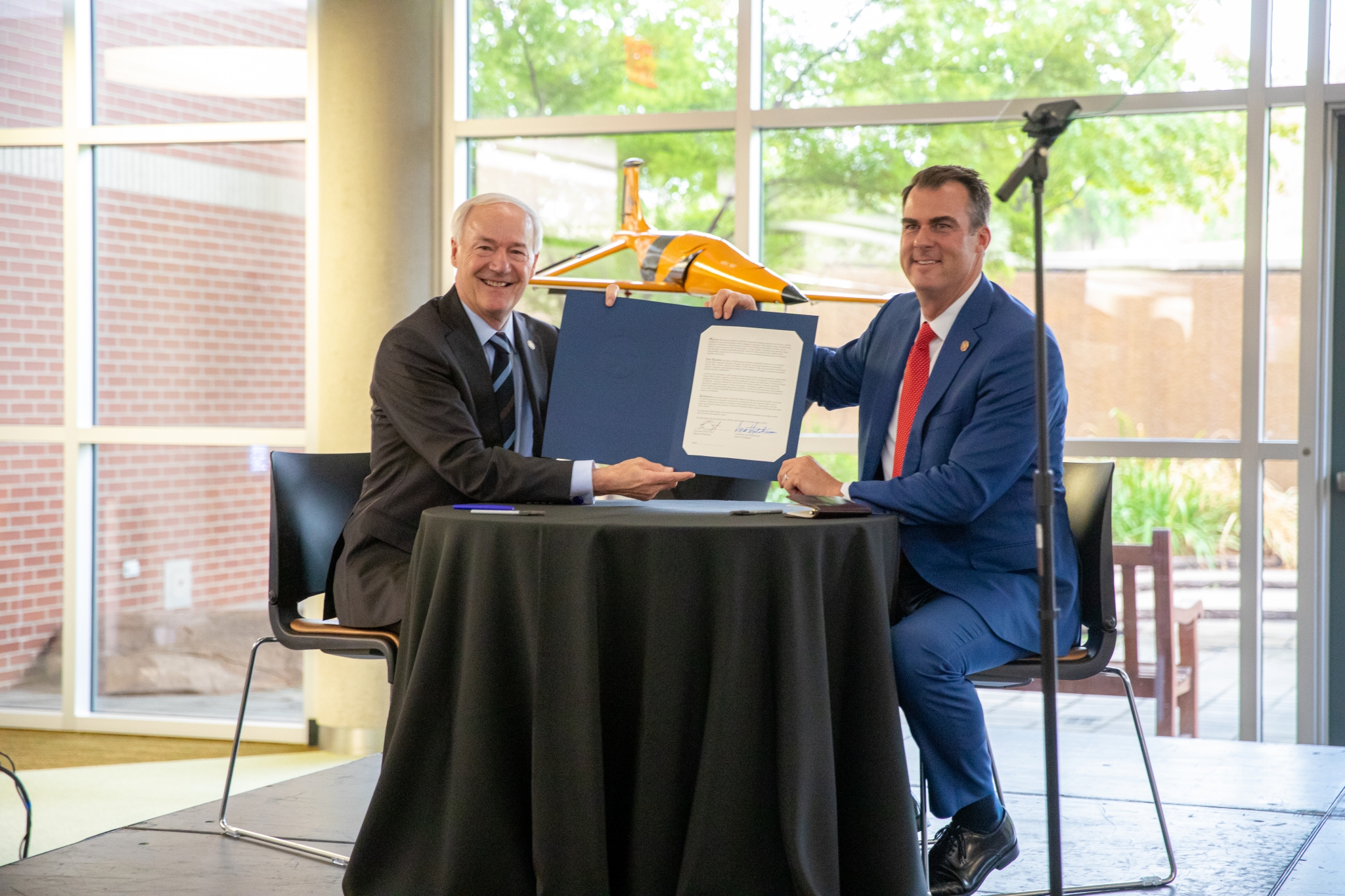 Governors Asa Hutchinson and Kevin Stitt sign the official agreement on Advanced Mobility between their respective states of AR and OK.