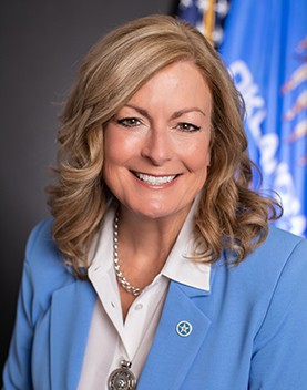 Headshot of Kim David in front of State of Oklahoma seal
