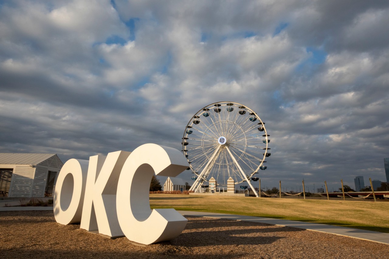 Large letters read OKC in front of ferris wheel in Wheeler District of Oklahoma City