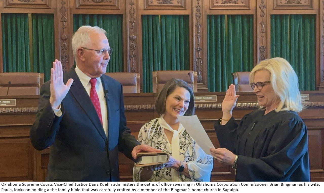Oklahoma Supreme Courts Vice-Chief Justice Dana Kuehn administers the oaths of office swearing in Oklahoma Corporation Commissioner Brian Bingman as his wife, Paula, looks on holding the family bible that was carefully crafted by a member of the Bingman's home church in Sapulpa