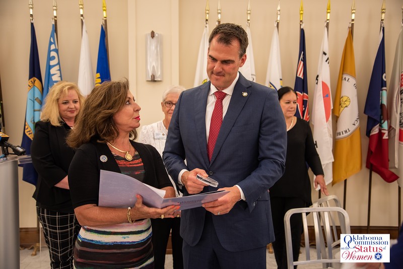 In picture is Governor Stitt with Victoria Woods, signing a collaboration project