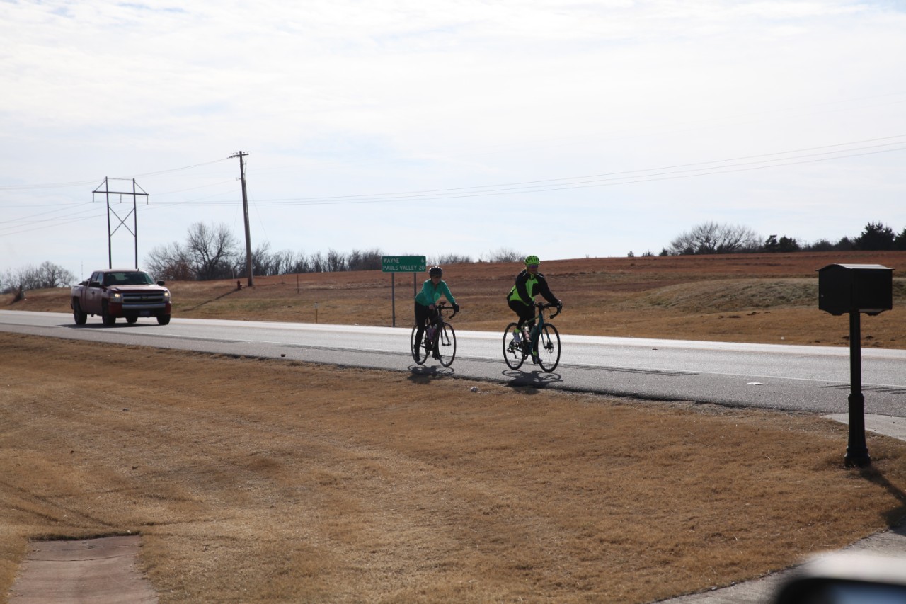 Bicycle riders on rural two-lane highway shoulder