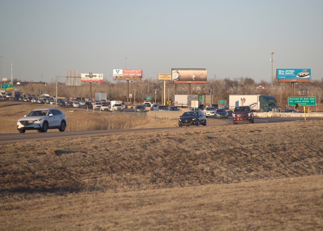 Traffic congestion at I-35 and SH-9 West with cars and trucks on the highway at evening rush hour