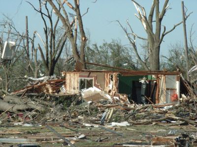 Photo of tornado damaged home missing front wall