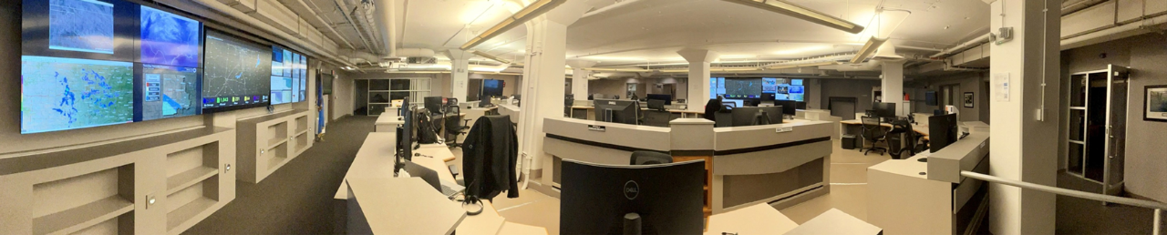 State of Oklahoma Emergency Operations Center  with multiple TV screens on the wall and computer stations in a circle.