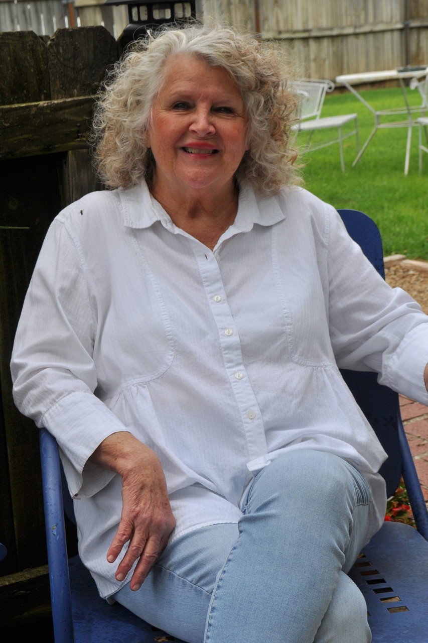 A woman sitting outside smiling