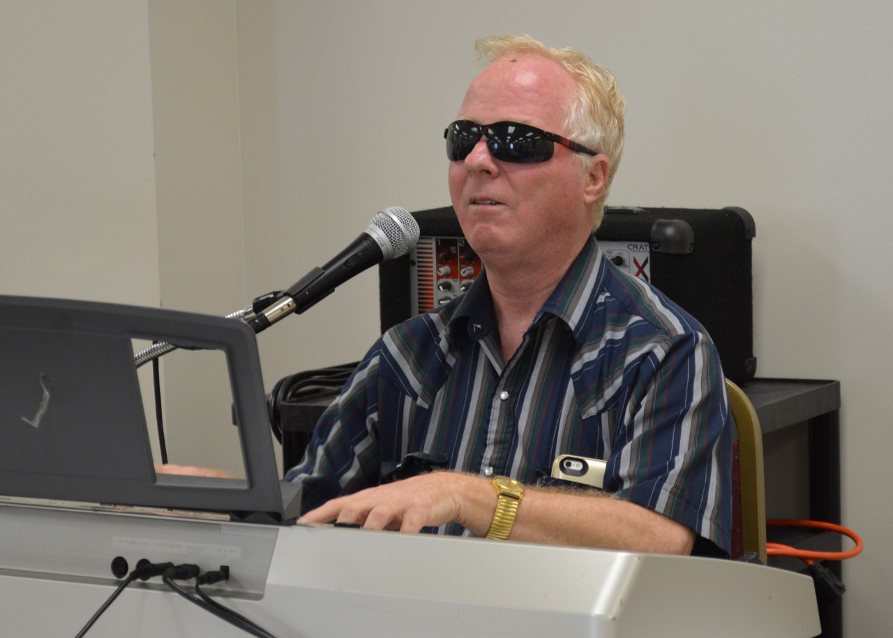 Man wearing sunglasses with microphone.