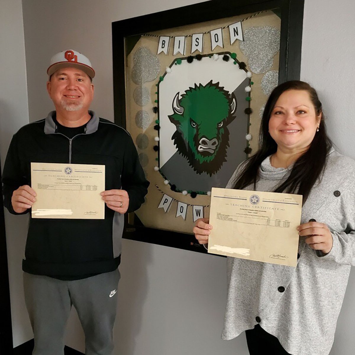 Man & woman hold certificates