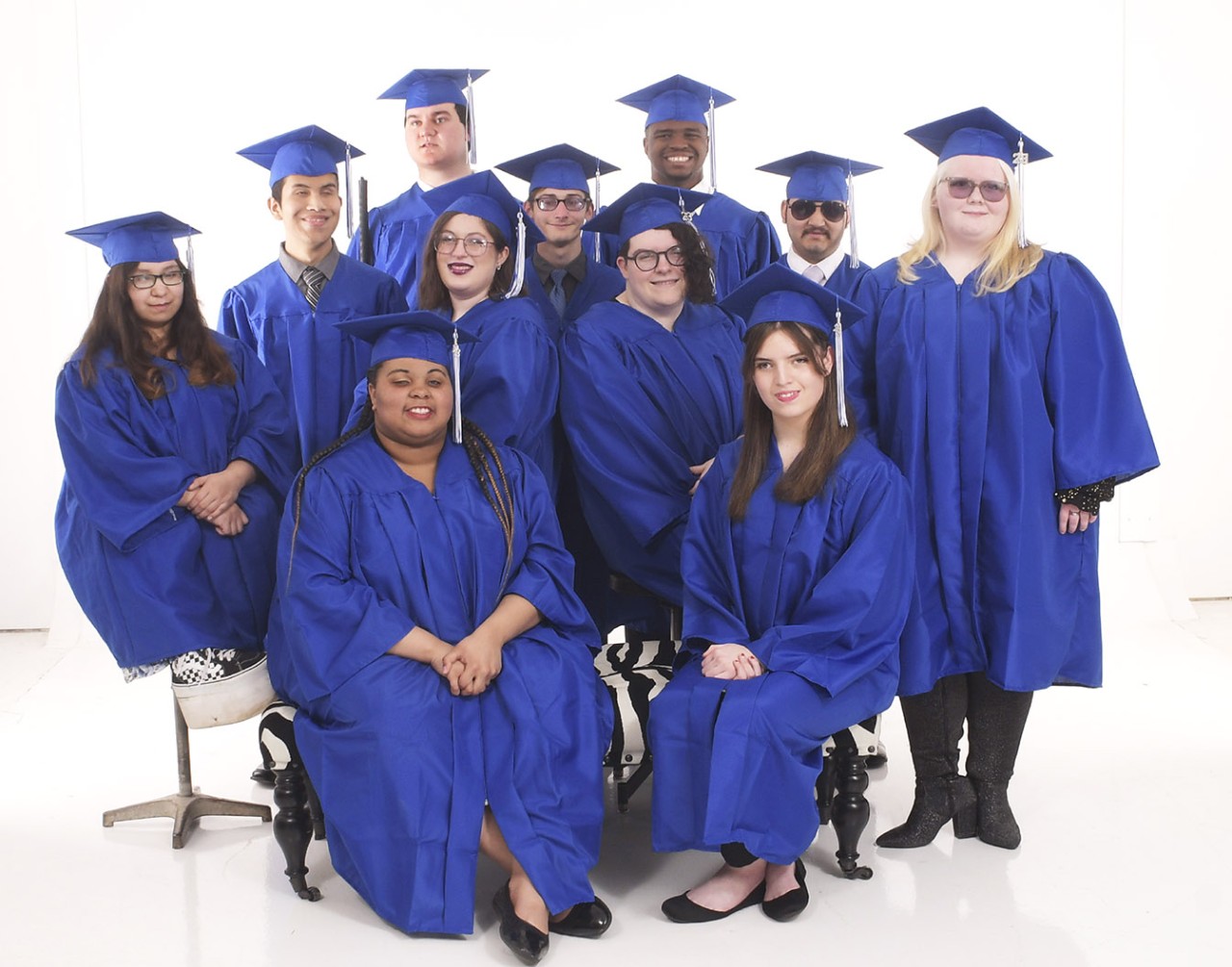 Eleven students wearing caps and gowns.