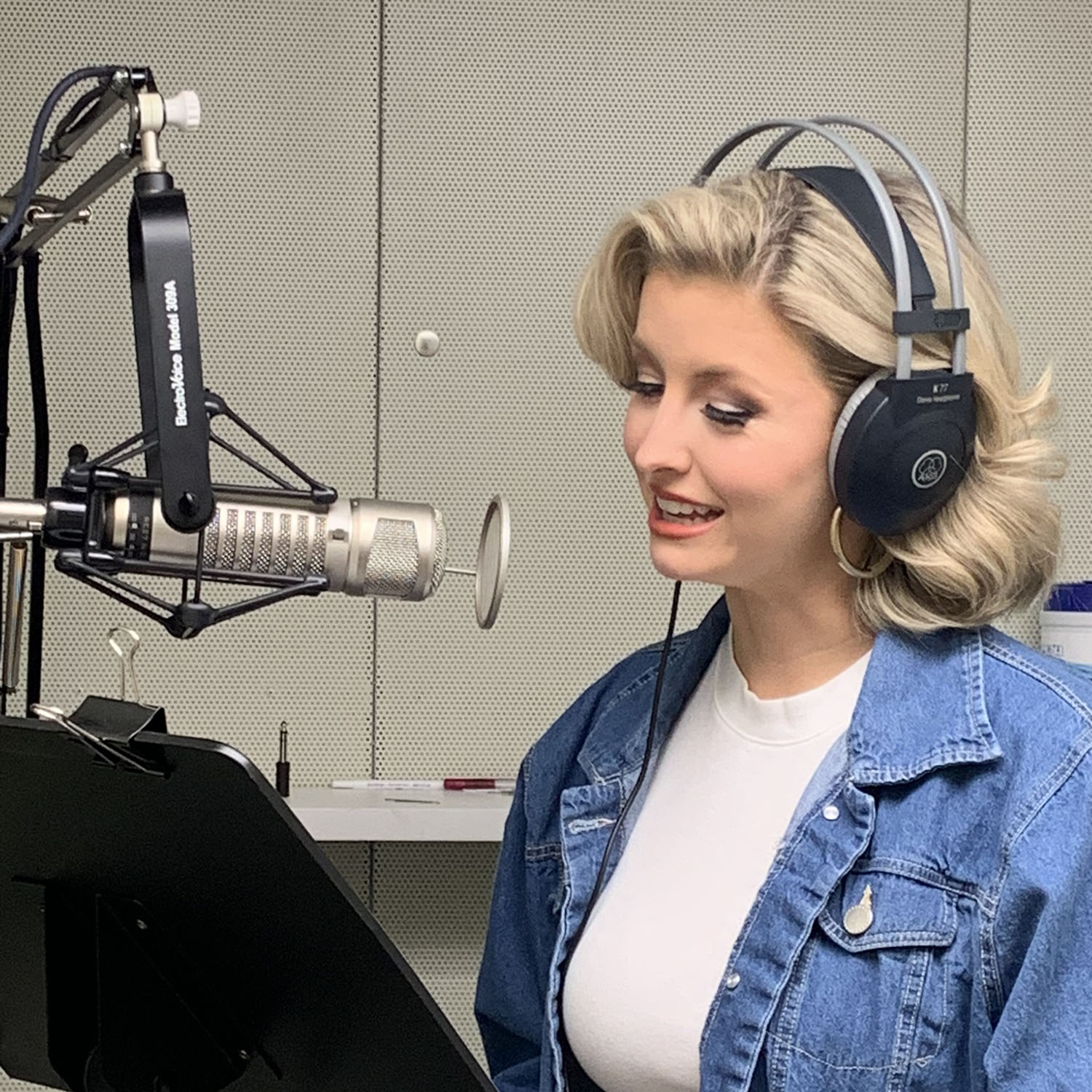 Woman wearing headphones speaks into a microphone