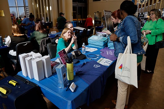Vendor speaks with attendees at 2025 People with Disabilities Awareness Day