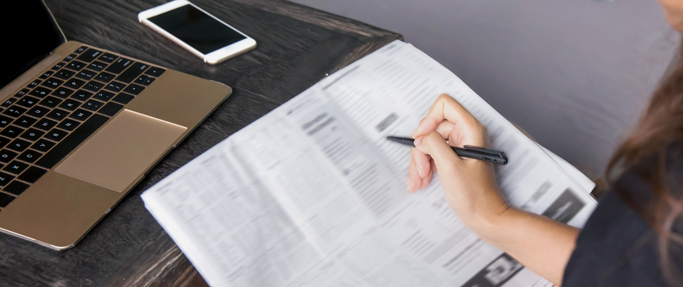 Person looking at a newspaper to a analyze job listings. Person looking at a newspaper to a analyze job listings.
