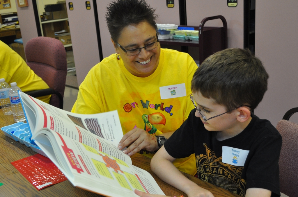 AIM Center a teacher is seen reading a book to a school boy
