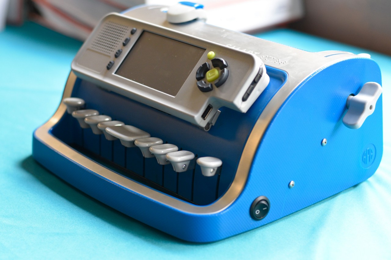 A bright-blue electronic brailler resting on a table. 