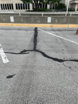 Close-up of large crack in Hodge building parking lot filled with fresh asphalt