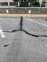 Close-up of large crack in Hodge building parking lot filled with fresh asphalt