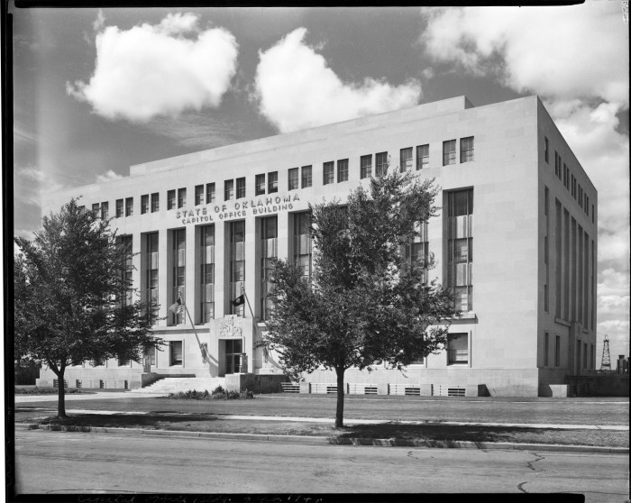 Black and white photo of the Jim Thorpe Building, previously deemed the Capitol Office Building. The photo is taken from the right side and shows the exterior front of the building. 